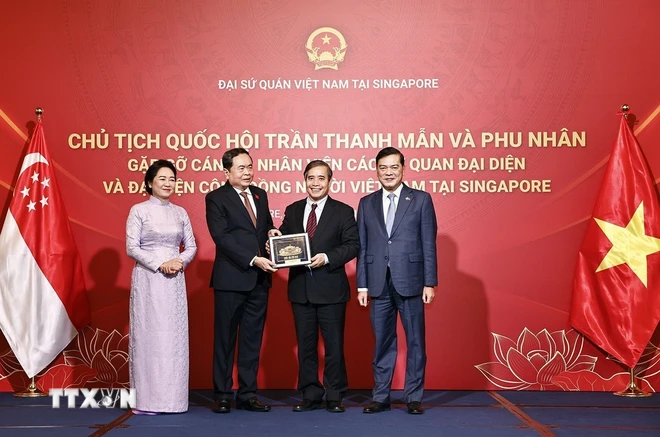 Chủ tịch Quốc hội Trần Thanh Mẫn và Phu nhân tặng quà lưu niệm đại diện cộng đồng người Việt Nam tại Singapore. (Ảnh: Doãn Tấn/TTXVN)