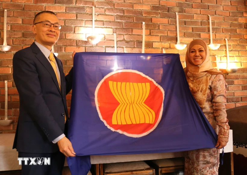 Đại sứ Việt Nam Vũ Quang Minh trao cờ ASEAN và chuyển giao vai trò Chủ tịch luân phiên Ủy ban ASEAN tại Berlin (BAC) cho Đại sứ Brunei Pengiran Krtini Pengiran Tahir. (Ảnh: Thu Hằng/TTXVN)
