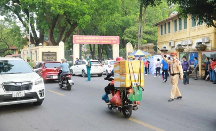 Cảnh sát giao thông phân luồng phương tiện trước cổng Trường Trung học Phổ thông Chu Văn An. (Ảnh: Hoài Nam/Vietnam+)