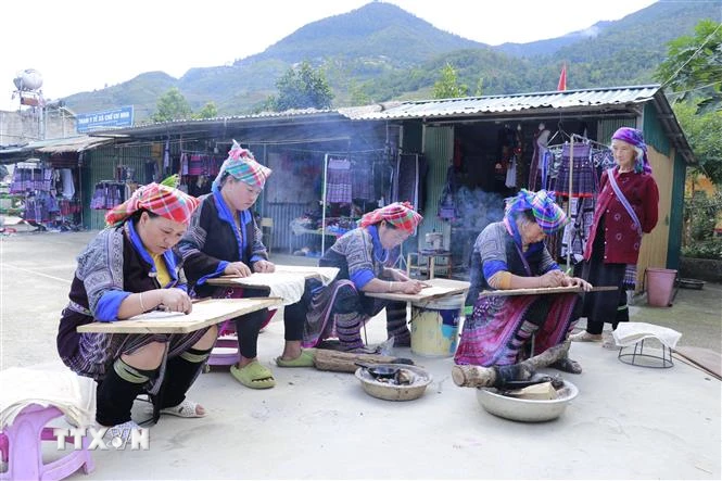 Những phụ nữ Mông tranh thủ vẽ mọi lúc khi có thời gian rảnh, ở mọi nơi khi có bếp lửa và khi sáp ong đã nóng chảy, đặc biệt là những lúc nông nhàn. (Ảnh: Tuấn Anh/TTXVN)