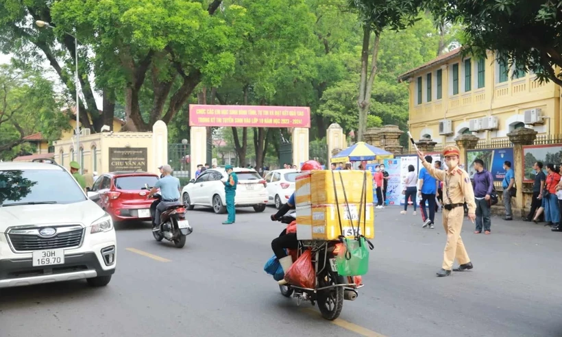 Cảnh sát giao thông phân luồng phương tiện trước cổng Trường Trung học Phổ thông Chu Văn An (Hà Nội). (Ảnh: Hoài Nam/Vietnam+)