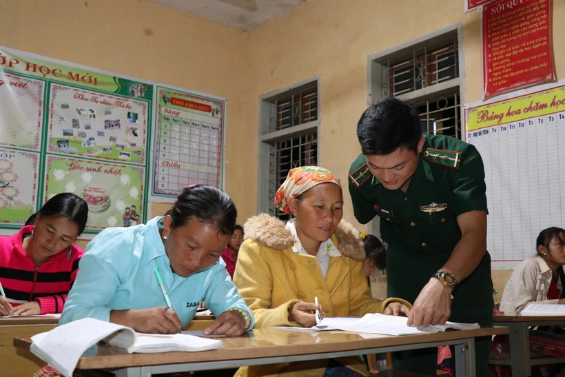 hầy giáo Vì Văn Liêm, Đồn biên Phòng Mường Lạn, hướng dẫn bà con học bài. (Ảnh: Hữu Quyết/TTXVN)