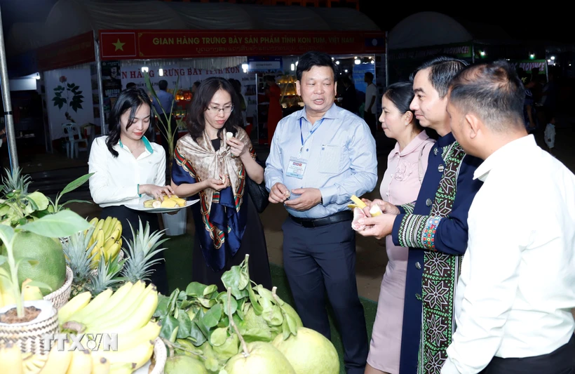 Các quan khách và người dân địa phương ăn thử các loại hoa quả do một doanh nghiệp Việt Nam trồng tại khu vực Tam giác Phát triển CLV. (Ảnh: Phạm Kiên/TTXVN)