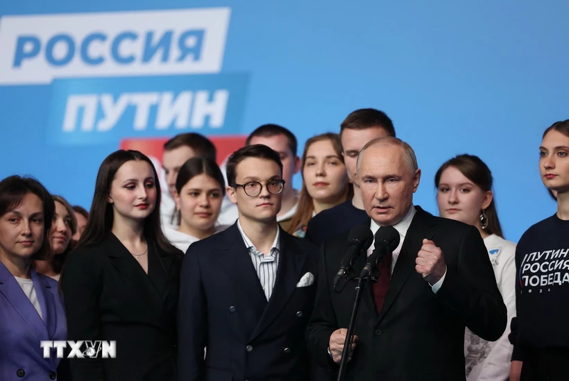 Tổng thống Nga Vladimir Putin (phía trước) trong cuộc gặp những người ủng hộ tại Moskva, sau khi kết quả bầu cử được công bố. (Ảnh: AFP/TTXVN)
