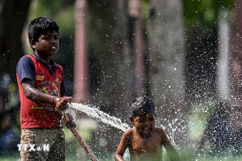 Trẻ em chơi đùa với nước trong ngày nắng nóng tại New Delhi, Ấn Độ, ngày 31/5. (Ảnh: AFP/TTXVN)