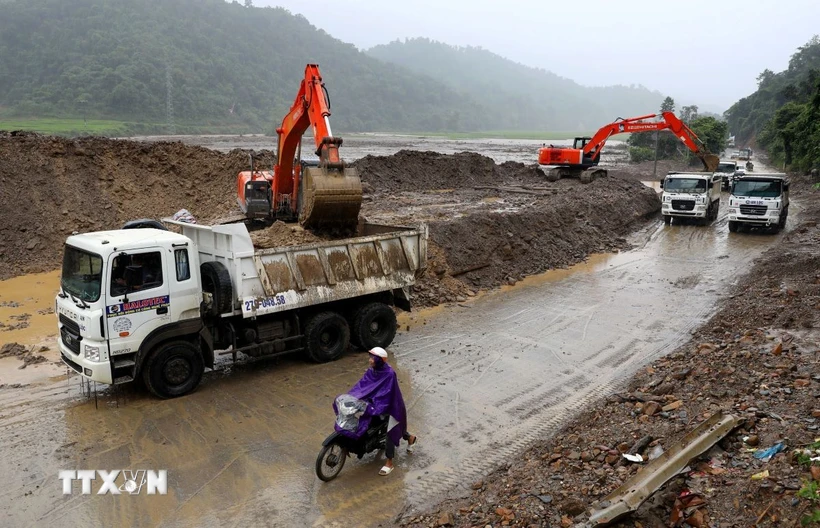 Các đơn vị ở Điện Biên bố trí nhiều máy móc, phương tiện để khắc phục sự cố, đảm bảo giao thông được thông suốt sau mưa lũ. (Ảnh: Trung Kiên/TTXVN)