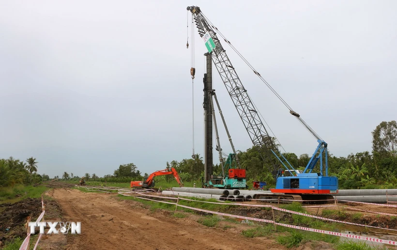 Công nhân làm việc tại gói thầu số 9 (huyện Mỹ Tú) thuộc dự án thành phần 4 thuộc Dự án Đầu tư xây dựng đường bộ cao tốc Châu Đốc-Cần Thơ-Sóc Trăng giai đoạn 1. (Ảnh: Tuấn Phi/TTXVN)