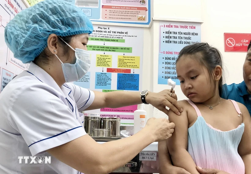 Nhân viên trạm Y tế phường An Lạc, quận Bình Tân tiêm vaccine phòng sởi cho trẻ. (Ảnh: Đinh Hằng/TTXVN)