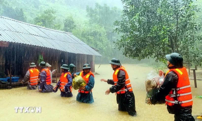 Bộ đội Biên phòng tỉnh Quảng Bình giúp người dân xã Kim Thủy, huyện Lệ Thủy vận chuyển tài sản ra khỏi vùng bị ngập sâu. (Ảnh: TTXVN phát)