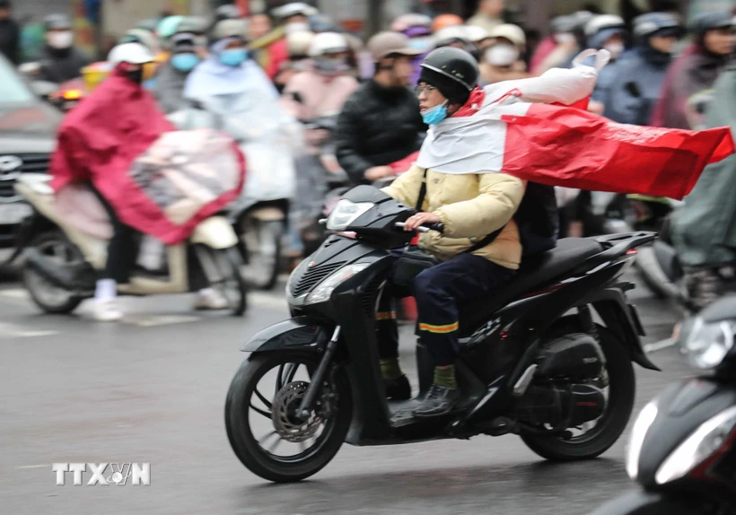 Người dân Hà Nội di chuyển trong mưa, rét. (Ảnh: Thanh Tùng/TTXVN)