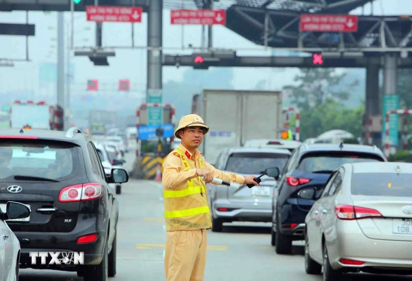 Cảnh sát giao thông điều tiết, phân luồng giao thông đoạn trạm thu phí cao tốc Pháp Vân-Cầu Giẽ. (Ảnh: Phạm Kiên/TTXVN)