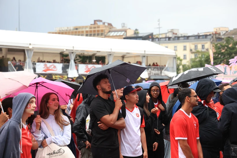 Trời mưa nhưng nhiều cổ động viên vẫn ở lại khu vực fanzone để cổ vũ đội tuyển Thụy Sĩ. (Ảnh: Anh Hiển/TTXVn)