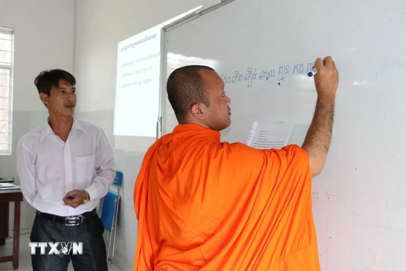 Tiến sỹ Tăng Văn Thòn (bên trái), Giảng viên Trường Ngôn ngữ- Văn hóa- Nghệ thuật Khmer Nam bộ và Nhân văn trong một buổi dạy ngôn ngữ Khmer tại trường. (Ảnh: Thanh Hòa/TTXVN)