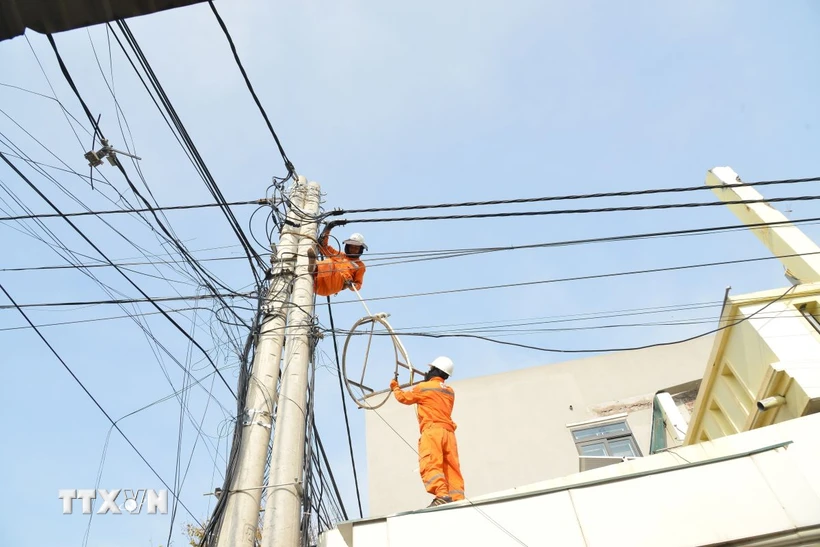 Cán bộ, công nhân ngành điện không ngại vất vả, nắng nóng khắc phục hệ thống điện cho người dân. (Ảnh: Thanh Vân/TTXVN)