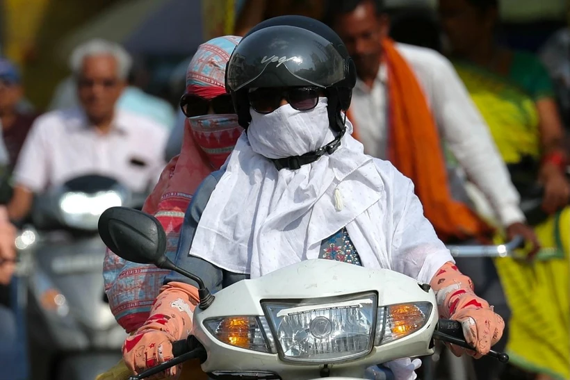 Người dân trùm kín tránh nắng nóng khi di chuyển tại Varanasi (Ấn Độ) ngày 16/4/2024. (Ảnh: AFP/TTXVN)