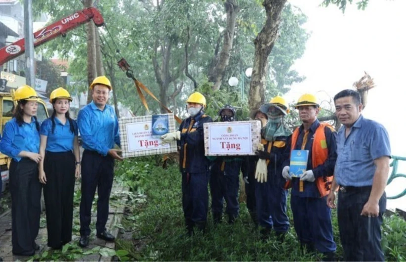 Lãnh đạo Công đoàn Thủ đô cùng Công đoàn ngành Xây dựng Hà Nội tặng quà công nhân Công ty Thoát nước Hà Nội. (Ảnh: TTXVN phát)