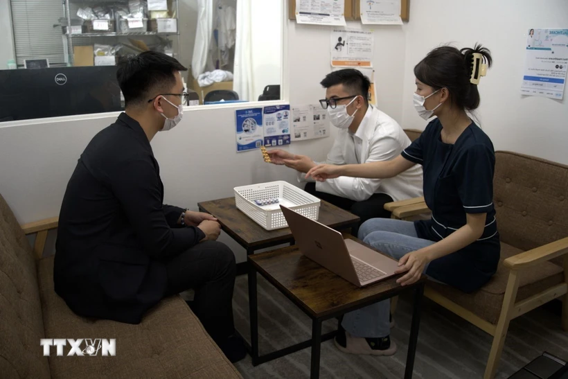 Một người Việt Nam đang được bác sỹ Nhật khám bệnh cùng với sự hỗ trợ của phiên dịch y tế người Việt. (Ảnh: Nguyễn Tuyến/TTXVN)