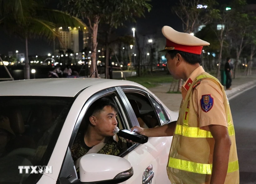 Cảnh sát Giao thông kiểm tra nồng độ cồn đối với người điều khiển xe ôtô. (Ảnh: Xuân Triệu/TTXVN)