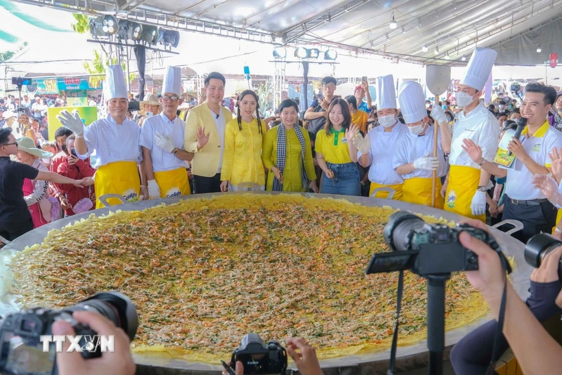 Chế biến chiếc bánh xèo khổng lồ với đường kính 3m phục vụ khách tham quan lễ hội ngày 18/4. (Ảnh: Thanh Liêm/TTXVN)