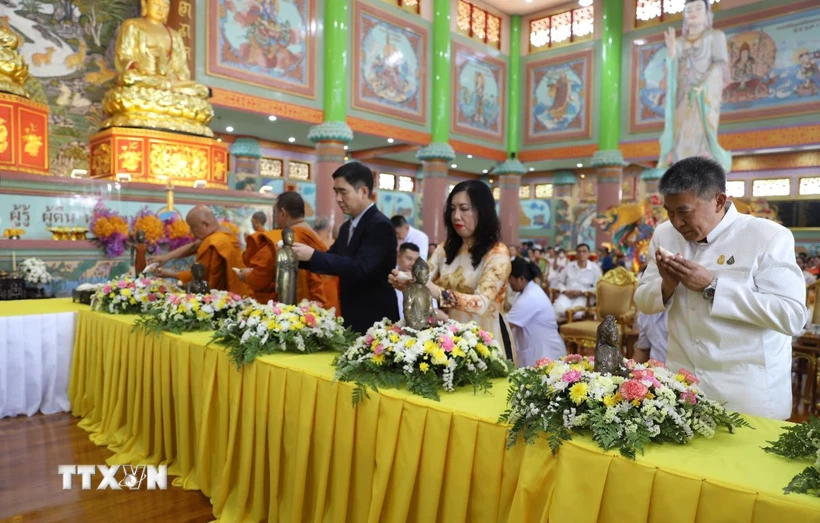 Thứ trưởng Ngoại giao Lê Thị Thu Hằng, Đại sứ Phạm Việt Hùng cùng các vị sư và Phật tử thực hiện nghi thức tắm tượng. (Ảnh: Đỗ Sinh/TTXVN)