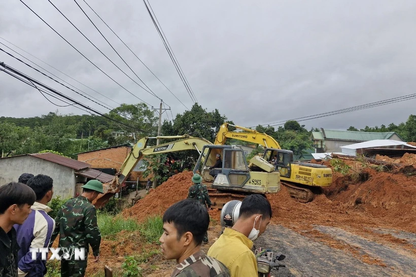 Lực lượng chức năng cùng thiết bị cơ giới triển khai công tác cứu hộ, giải tỏa hiện trường. (Ảnh: TTXVN phát)