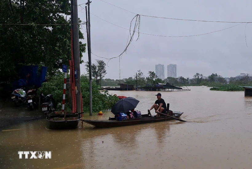 Học sinh sinh sống ở khu vực ven sông Hồng thuộc phường Chương Dương (Hoàn Kiếm) phải đi học bằng thuyền. (Ảnh: TTXVN phát)