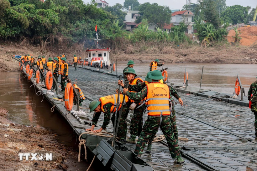 Lực lượng công binh đang triển khai lắp đặt cầu phao. (Ảnh: Hoàng Hiếu/TTXVN)