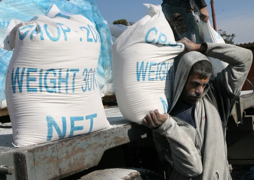 Người dân Palestine nhận lương thực viện trợ nhân đạo tại trại tị nạn ở Rafah, miền Nam Dải Gaza, giáp giới với Ai Cập. Ảnh: AFP/TTXVN