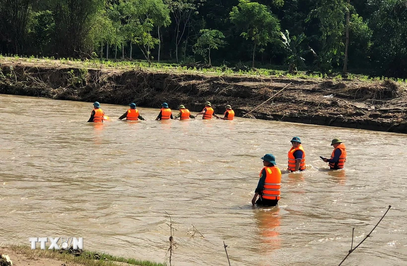 Huy động lực lượng tìm kiếm nạn nhân bị lũ cuốn. (Ảnh: TTXVN phát)