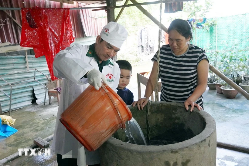 Quân y Bộ đội Biên phòng tỉnh Quảng Bình hỗ trợ người dân vùng lũ huyện Lệ Thủy khử khuẩn nguồn nước sinh hoạt. (Ảnh: TTXVN phát)