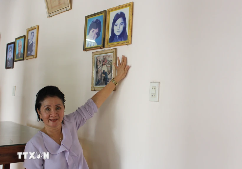 Bà Nguyễn Thị Ngọc Bích kể chuyện về sự kiện gia đình bà may 2 lá cờ giải phóng trước những năm 1975 và hình ảnh của chị gái-liệt sỹ Nguyễn Thị Ngọc Oanh. (Ảnh: Phan Sáu/ TTXVN)