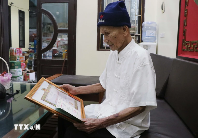 Cựu thanh niên xung phong Nguyễn Đức Cán, sinh năm 1934, xã Hiên Vân, huyện Tiên Du, tỉnh Bắc Ninh bên tấm huy hiệu 55 năm tuổi Đảng. (Ảnh: Thanh Thương/TTXVN)