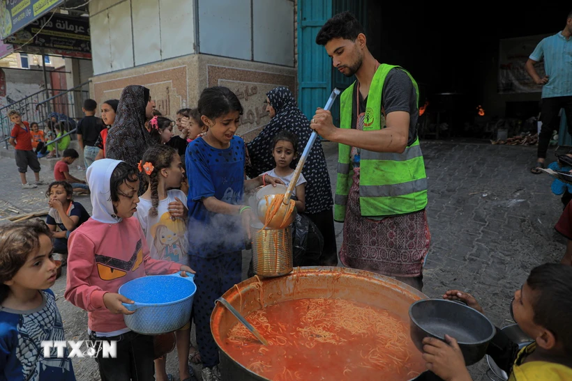 Các em nhỏ nhận thực phẩm cứu trợ tại thành phố Rafah, Dải Gaza, ngày 28/4/2024. Ảnh: THX/TTXVN