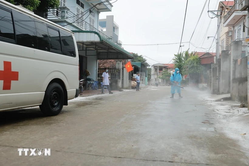 Nhân viên y tế phun thuốc khử khuẩn tại xóm Bến Vôi, xã Cấn Hữu sau khi nước rút. (Ảnh: Minh Quyết/TTXVN)