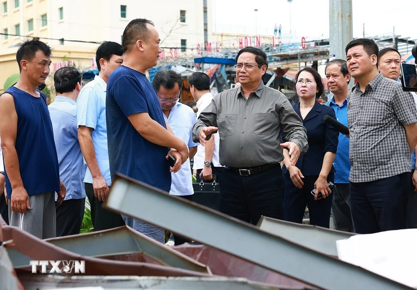 Thủ tướng Phạm Minh Chính động viên người dân bị ảnh hưởng do cơn bão số 3 gây ra tại Quảng Ninh. (Ảnh: Dương Giang/TTXVN)