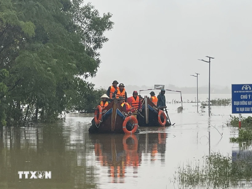 Các lực lượng chức năng di chuyển bằng thuyền hỗ trợ người dân vùng ngập lụt ở Quảng Trị. (Ảnh: Thanh Thủy/TTXVN)