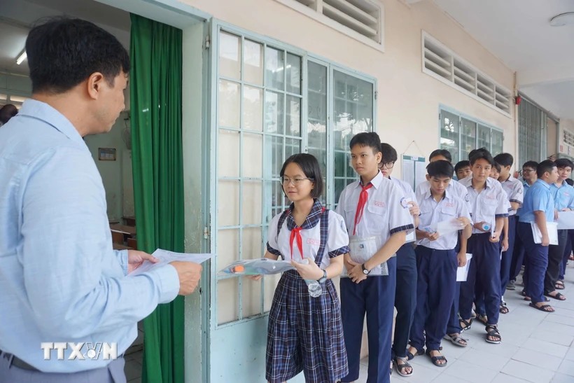 Thí sinh tại điểm thi Trường THCS Lê Quý Đôn (thành phố Thủ Đức) chờ điểm danh vào phòng thi. (Ảnh: Thu Hoài/TTXVN)