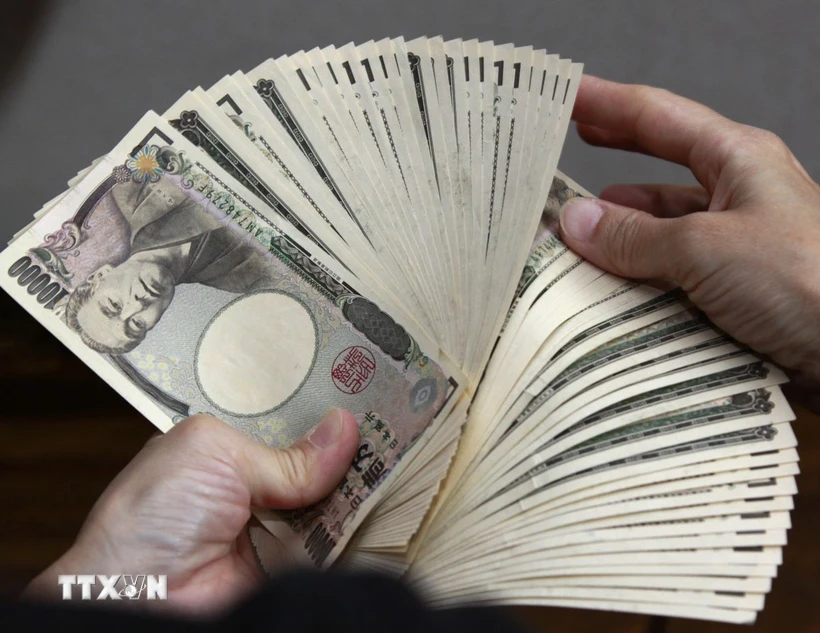 Kiểm tiền mệnh giá 10.000 yen tại Tokyo, Nhật Bản. (Ảnh: AFP/TTXVN)