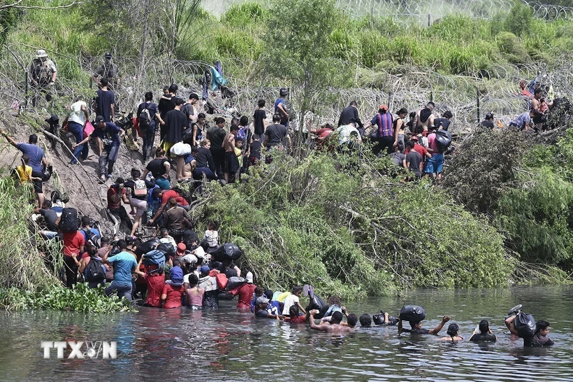 Người di cư vượt sông từ Mexico vào Mỹ ngày 11/5/2023. (Ảnh: Getty Images/TTXVN)