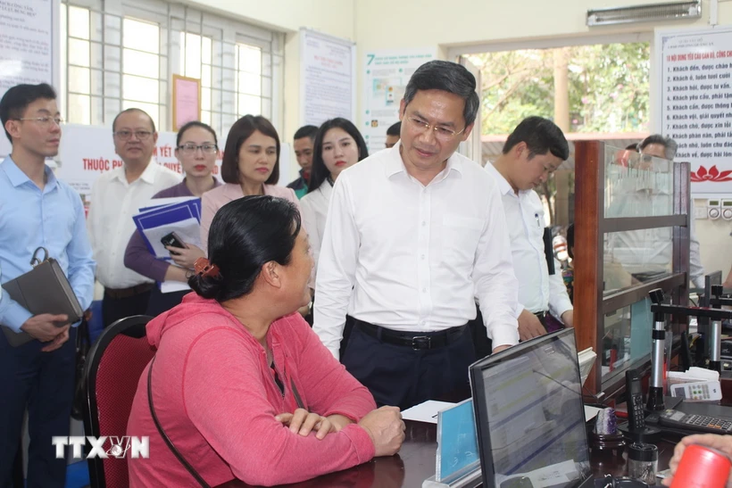 Phó Chủ tịch UBND thành phố Hà Nội Hà Minh Hải trao đổi với người dân làm thủ tục hành chính tại UBND phường Quảng An, quận Tây Hồ, Hà Nội. (Ảnh: Nguyễn Thắng/TTXVN)