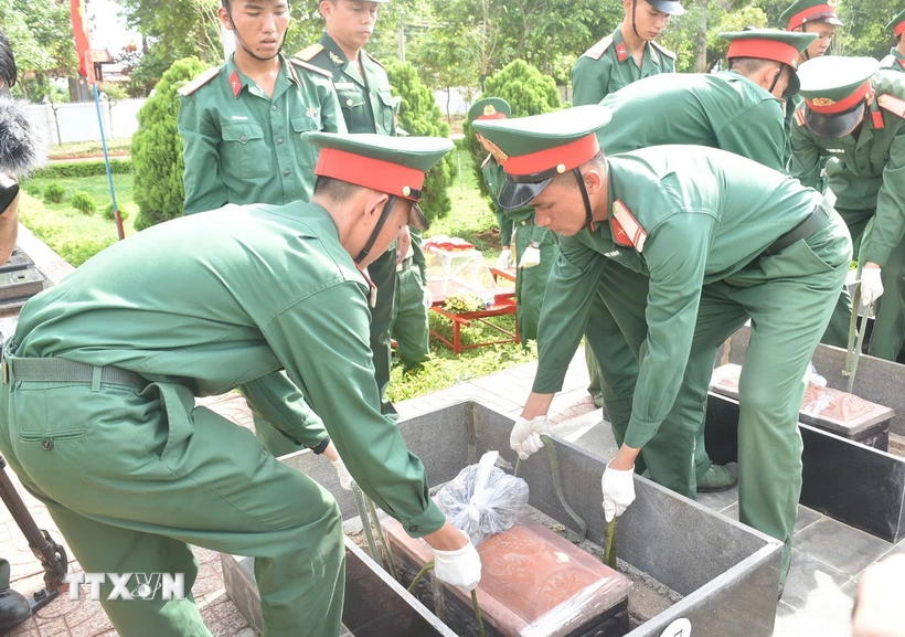 Nghi thức hạ quan hài cốt các liệt sỹ. (Ảnh: Nguyên Dung/TTXVN)