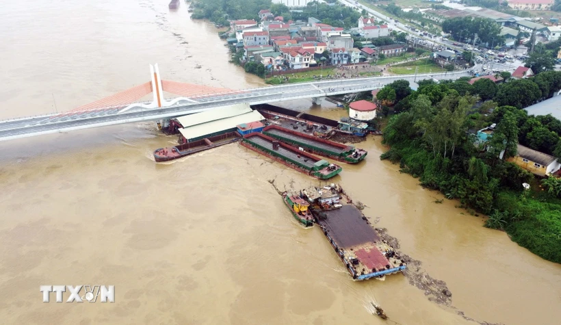 Nhiều tàu chở hàng và sà lan bị mắc kẹt dưới chân cầu Vĩnh Phú thuộc địa bàn phường Dữu Lâu, thành phố Việt Trì, tỉnh Phú Thọ, sáng 10/9. (Ảnh: Tạ Toàn/TTXVN)