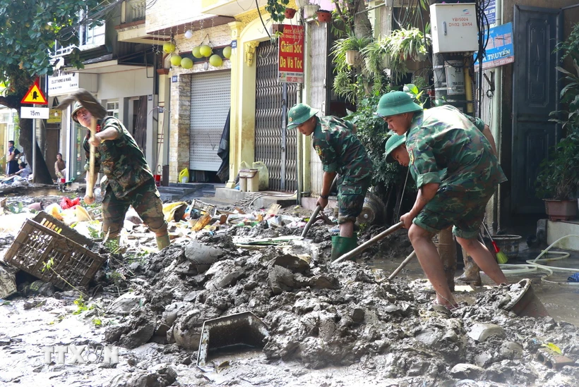 Cán bộ, chiến sỹ Trung đoàn 174, Sư đoàn 316, Quân khu 2, được huy động hỗ trợ dọn bùn, giúp người dân thành phố Yên Bái sớm ổn định cuộc sống sau đợt lũ. (Ảnh: Tuấn Anh/TTXVN)