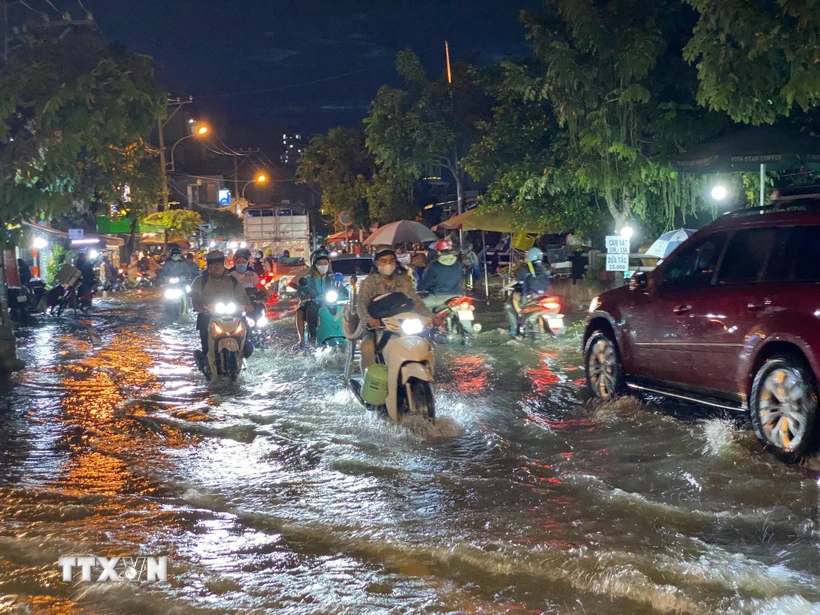 Các phương tiện di chuyển khó khăn khi triều cường gây ngập trên đường Trần Xuân Soạn, quận 7. (Ảnh: Hồng Giang/TTXVN)