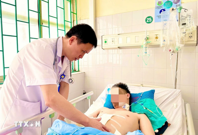 Bác sỹ Lê Ngọc Sơn, Phó Khoa Cấp cứu-Hồi sức tích cực 2, thăm khám cho bệnh nhân trước khi xuất viện. (Ảnh: TTXVN phát)