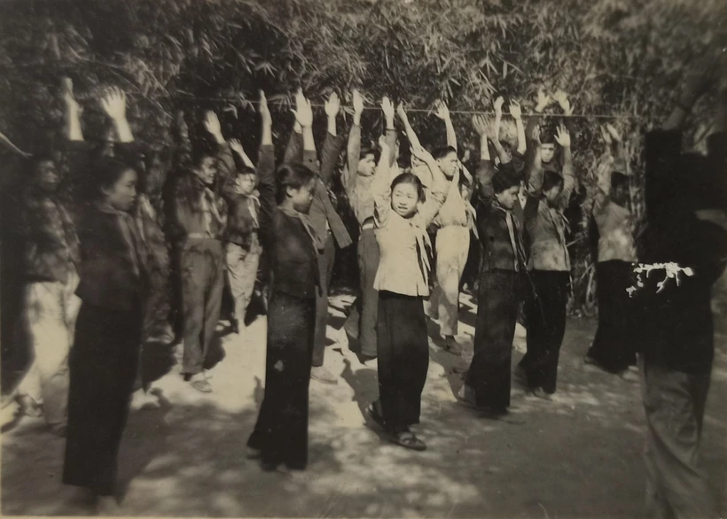 Giờ tập thể dục giữa giờ của học sinh Trường Pom Lót khi sơ tán trong rừng tre, năm học 1964-1965. (Ảnh: NVCC)