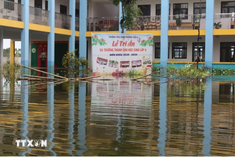 Sân trường Trung học cơ sở Nam Phương Tiến A bị ngập sâu. (Ảnh: Nguyễn Cúc/TTXVN)