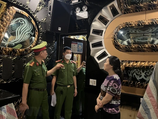 Lực lượng chức năng tiến hành kiểm tra một cơ sở karaoke tại quận Hoàn Kiếm. (Ảnh TTXVN)