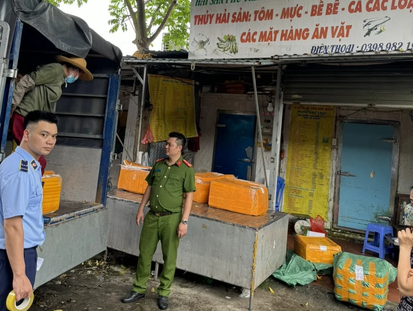 Lực lượng Quản lý Thị trường phối hợp với Công an Hà Nội kiểm tra thực phẩm. (Ảnh: PV/Vietnam+)