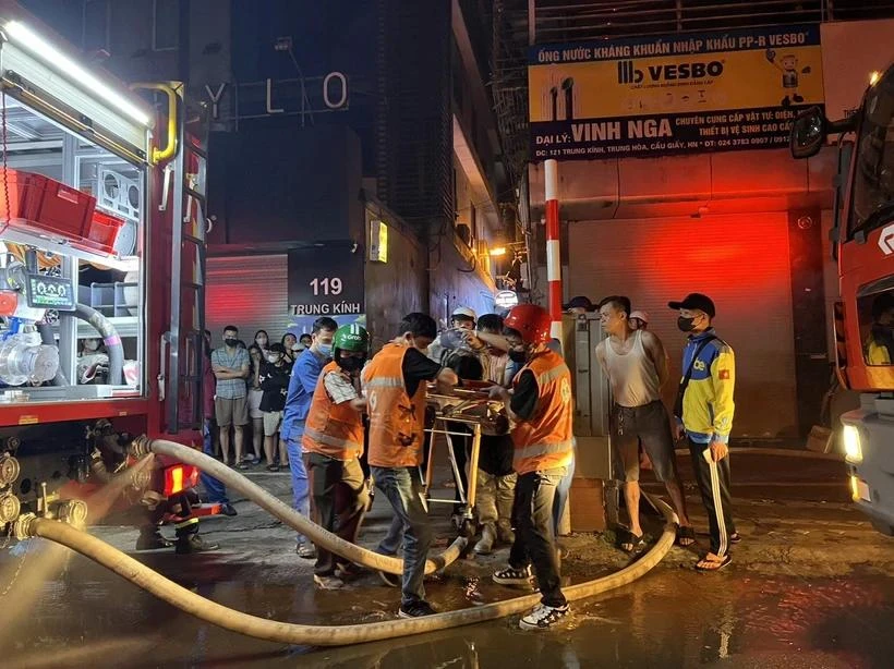 Các nạn nhân được đưa ra ngoài trong vụ cháy rạng sáng 24/5 tại Trung Kính (Cầu Giấy, Hà Nội). (Ảnh: PV/Vietnam+)